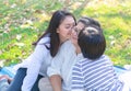 Asian lovely young daughter and grandson kiss happy and healthly senior woman or pleasure grandmother in moment of beautiful love