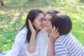 Asian lovely young daughter and grandson kiss happy and healthly senior woman or pleasure grandmother in moment of beautiful love