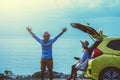 Asian lover couple woman and man travel nature. Travel relax. Sitting on the car at the beach. In the summer