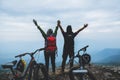 Asian lover woman and man Travel Nature. Travel relax ride a bike Wilderness in the wild. Standing on a rocky cliff. Thailand