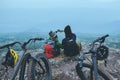 Asian lover women and men Travel Nature. Travel relax ride Mountain Bike in the wild. Sit down on a rocky cliff. Thailand