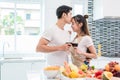 Asian lovers or couples kissing forehead and drinking wine in kitchen room at home. Love and happiness concept Sweet honeymoon