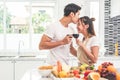 Asian lovers or couples kissing forehead and drinking wine in kitchen room at home. Love and happiness concept Sweet honeymoon