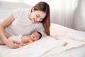 Asian loving mom carying of her newborn baby at home. Happy mum holding sleeping infant child on hands. Mother hugging her little Royalty Free Stock Photo