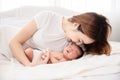 Asian loving mom carying of her newborn baby at home. Happy mum holding sleeping infant child on hands. Mother hugging her little Royalty Free Stock Photo