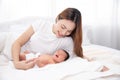 Asian loving mom carying of her newborn baby at home. Happy mum holding sleeping infant child on hands. Mother hugging her little Royalty Free Stock Photo