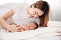 Asian loving mom carying of her newborn baby at home. Happy mum holding sleeping infant child on hands. Mother hugging her little Royalty Free Stock Photo