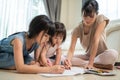 Asian loving parent spend time with small cute kid daughter enjoy activity at house. Little siblings girl artist having fun draw a Royalty Free Stock Photo