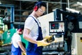 Asian machine operator in production plant Royalty Free Stock Photo