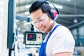 Asian machine operator in production plant Royalty Free Stock Photo