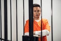 Asian mafia gang member is serving time behind bars. Sad portrait in a prison cell.