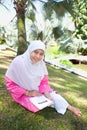 Asian Malay Muslim woman reading