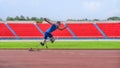 Asian male athlete, prosthetics user, sprints off from block start, powering his practice run on stadium track