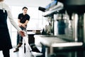 Asian male barista teacher sitting on the counter and waiting for the class ready. Coffee-making class for start-up entrepreneurs