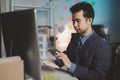 Asian male businessman working in the room. Startup company employees are working in the office at night, overtime, busy work, Royalty Free Stock Photo
