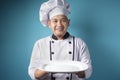 Asian Male Chef Shows Empty White Plate, Presenting Something, Copy Space Royalty Free Stock Photo