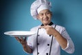 Asian Male Chef Shows Empty White Plate, Presenting Something, Copy Space Royalty Free Stock Photo