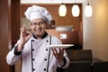 Asian Male Chef Shows Empty White Plate, Presenting Something, Copy Space Royalty Free Stock Photo