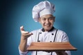 Asian Male Chef Shows Empty Wooden Plate, Presenting Something, Copy Space Royalty Free Stock Photo