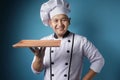 Asian Male Chef Shows Empty Wooden Plate, Presenting Something, Copy Space Royalty Free Stock Photo