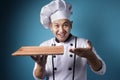 Asian Male Chef Shows Empty Wooden Plate, Presenting Something, Copy Space Royalty Free Stock Photo