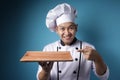 Asian Male Chef Shows Empty Wooden Plate, Presenting Something, Copy Space Royalty Free Stock Photo