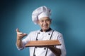 Asian Male Chef Shows Empty Wooden Plate, Presenting Something, Copy Space Royalty Free Stock Photo