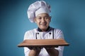 Asian Male Chef Shows Empty Wooden Plate, Presenting Something, Copy Space Royalty Free Stock Photo