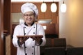 Asian Male Chef Shows Empty Wooden Plate, Presenting Something, Copy Space Royalty Free Stock Photo