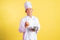asian male chef smiling while using whisk with mixing bowl Royalty Free Stock Photo