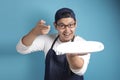 Asian Male Chef or Waiter Shows Empty White Plate, Presenting Something, Copy Space Royalty Free Stock Photo