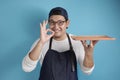 Asian Male Chef or Waiter Shows Empty Wooden Plate, Presenting Something, Copy Space Royalty Free Stock Photo