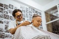 asian male client getting hair cut in barbershop Royalty Free Stock Photo