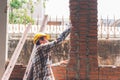 Asian male construction engineer Checking the orderliness of the brick wall work Royalty Free Stock Photo