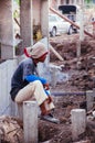 Asian male construction labour sit on concrete pillar at construction site