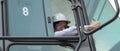 Asian male container forklift driver operating container forklift in driver cabin at containers yard and cargo