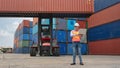 Asian male containers cargo inspector working and containers yard and cargo with background of containers stack and container