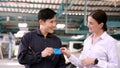 Asian male craftsman\'s portrait and a caucasian woman handing credit cards to each other man taking credit card Royalty Free Stock Photo