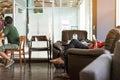 Asian male customer wear face mask using smartphone while sit in waiting social distance queue for take away drink in coffee shop