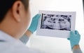 Asian male dentists are analyzing x-ray images of patients at the lab