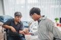 Asian male doctor is checking the hand with a kink of middle aged male patients