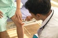 An Asian male doctor examining the reactions of an Asian male patient. neurologist using a knee hammer which is a medical device. Royalty Free Stock Photo