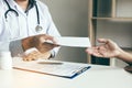 Asian male doctor talking in clinic room and handing a prescript Royalty Free Stock Photo