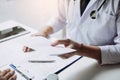 Asian male doctor talking in clinic room and handing a prescription to the patient Royalty Free Stock Photo