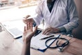 Asian male doctor talking in clinic room and handing a prescription to the patient Royalty Free Stock Photo