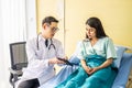 Asian male doctor talking to asian female patient in bed, while explaining exam results in computer to patient at medical Royalty Free Stock Photo