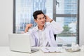 Asian male doctor typing on laptop computer while sitting at the Royalty Free Stock Photo