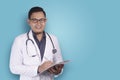 Asian Male Doctor Writing on Clipboard Royalty Free Stock Photo