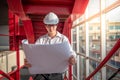 Asian male engineer holding blueprints at construction site Royalty Free Stock Photo