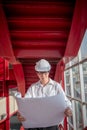 Asian male engineer holding blueprints at construction site Royalty Free Stock Photo